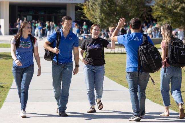 CALS students walking and talking together in front of the Reitz Union on campus.